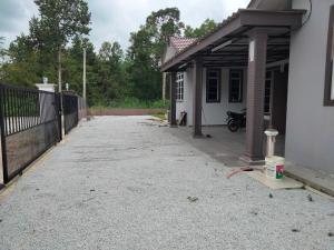 a driveway of a house with a fence at Warisan homestay jerteh in Jertih