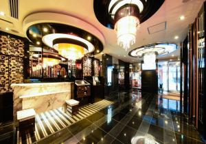 eine Lobby eines Hotels mit einer Bar und Kronleuchtern in der Unterkunft APA Hotel Midosujihonmachieki Higashi in Osaka