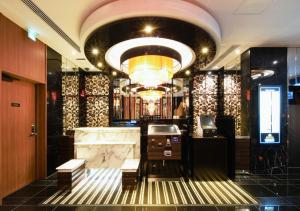 eine Lobby mit einem großen Kronleuchter und einer Bar in der Unterkunft APA Hotel Midosujihonmachieki Higashi in Osaka