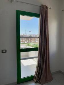 - une fenêtre avec un rideau vert dans la chambre dans l'établissement City Center Apartment - Neama Bay, à Charm el-Cheikh