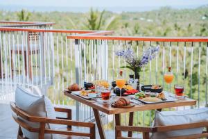 une table avec de la nourriture et des boissons sur un balcon dans l'établissement Varivana Resort Koh Phangan, The Centara Collection, à Thongsala