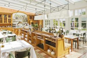 a restaurant with a bar with white tables and chairs at Hotel De Bilderberg in Oosterbeek