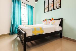 Schlafzimmer mit einem Bett mit blauen Vorhängen in der Unterkunft OYO Home KC Arcade in Kochi