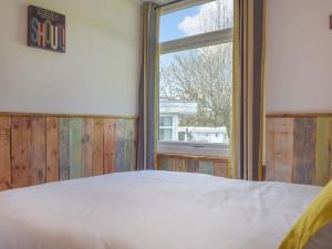 um quarto com uma cama e uma janela em Ty Haf em Roch