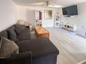 sala de estar con sofá y TV en Thistle Dew en Great Yarmouth