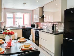 a kitchen with a table with plates on it at Thistle Dew in Great Yarmouth