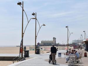 a man riding a stroller on a sidewalk near the beach at Thistle Dew in Great Yarmouth