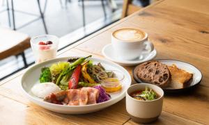 uma mesa com um prato de comida e uma chávena de café em HOTEL RINGS KYOTO em Quioto