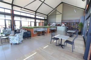 a restaurant with tables and chairs in a building at The Parks Airport Apartment in Boksburg