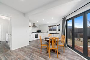 a kitchen and dining room with a table and chairs at Lake Dunstan Cottage - Cromwell Holiday Home in Cromwell