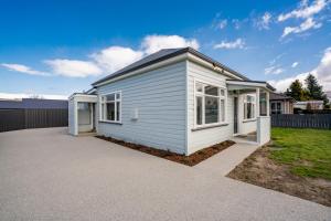 a white tiny house with a driveway at Lake Dunstan Cottage - Cromwell Holiday Home in Cromwell