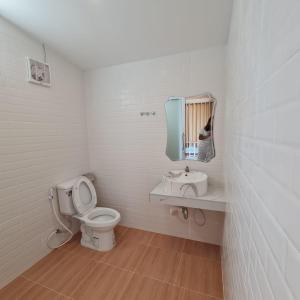 a bathroom with a toilet and a sink and a mirror at นอร์ดิกเฮ้าส์ แอนด์ คอฟฟี่หนองบัวลำภู in Ban Huai Luk