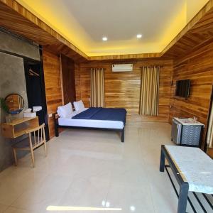 ein Schlafzimmer mit einem Bett und einem TV. in der Unterkunft นอร์ดิกเฮ้าส์ แอนด์ คอฟฟี่หนองบัวลำภู in Ban Huai Luk