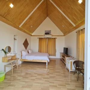 a bedroom with a bed and a tv in a room at นอร์ดิกเฮ้าส์ แอนด์ คอฟฟี่หนองบัวลำภู in Ban Huai Luk