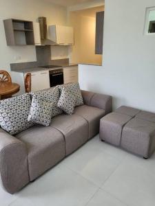 a living room with a couch and a kitchen at Elegant 1-bedroom apartment with close amenities in Quatre Bornes