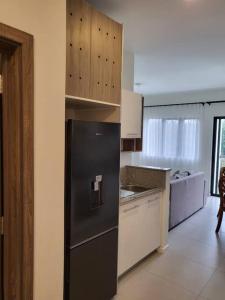 a kitchen with a black refrigerator in a room at Elegant 1-bedroom apartment with close amenities in Quatre Bornes