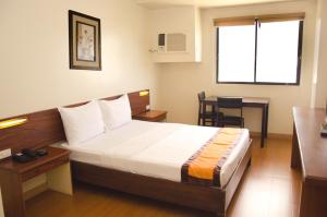 Postel nebo postele na pokoji v ubytování M Suites Hotel