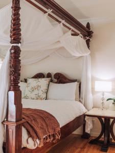 a canopy bed with a wooden frame in a bedroom at Romantic Cottage, Tamborine Mountain in Mount Tamborine