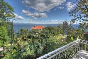 a house on a hill with trees and the ocean at Premium Apartments Punta Kolova in Opatija