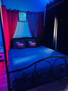 a bedroom with a bed with blue and red lights at Douceur d’une nuit (studio avec jaccuzi privatif) in Vitrolles