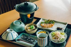 uma bandeja de comida numa mesa com um bule de chá em 温泉グランピングWooods芸北 
