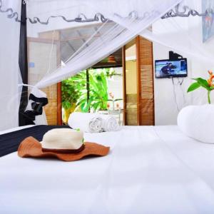 a white bed with a pile of towels on it at Conch Villa in Tangalle