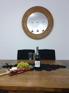 una mesa con una botella de vino y un espejo en The Tribe House Kiama, en Kiama