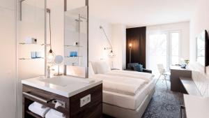 Cette chambre comprend un lit et un bureau. dans l'établissement Dorint Hotel Düren, à Düren