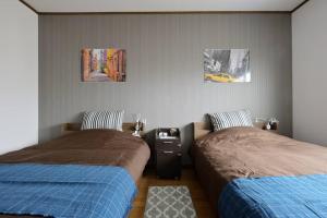 Guest House TIHARU 6bedrooms12people max and Straight to USJ and Near the hot springにあるベッド
