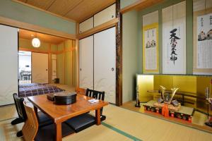 大阪市にあるGuest House TIHARU 6bedrooms12people max and Straight to USJ and Near the hot springのテーブルと椅子のあるダイニングルームと寝室