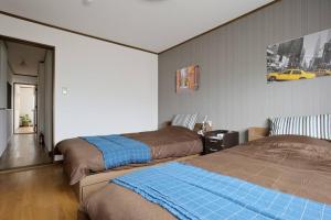 大阪市にあるGuest House TIHARU 6bedrooms12people max and Straight to USJ and Near the hot springのベッドルーム1室(ベッド2台付)が備わります。壁に黄色い車が1台あります。