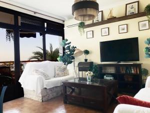salon z białą kanapą i telewizorem w obiekcie Primera Linea de Playa con vistas al Mar w mieście Águilas