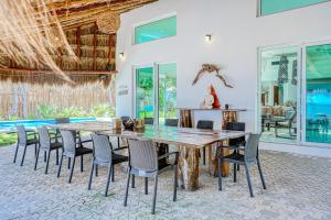 a dining room with a large wooden table and chairs at Villa Tankah Mandala in Tulum