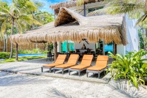 a group of chairs and a table and a building at Villa Tankah Mandala in Tulum