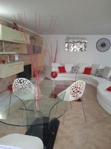 a living room with a glass table and two chairs at Appartamento Villa Serena due in Maracalagonis