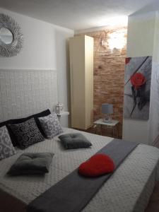 Un dormitorio con una cama con una almohada roja. en Appartamento Villa Serena due, en Maracalagonis