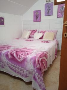 1 dormitorio con 1 cama con manta rosa en Appartamento Villa Serena due, en Maracalagonis