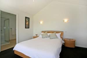 a bedroom with a large white bed with two pillows at A River Bed in Aireys Inlet