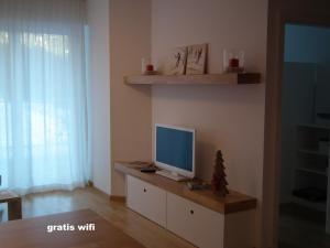 uma sala de estar com uma televisão num armário com um monitor em Nassfeld Apartments - "Traditionell anders" em Sonnenalpe Nassfeld