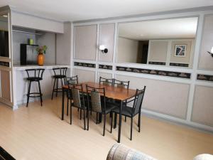 a dining room with a table and chairs and a kitchen at Holiday Plaza Hotel - Cebu in Cebu City