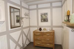 ein Badezimmer mit einer Holzkommode und einem Spiegel in der Unterkunft Ferienwohnungen Herzog in Haundorf