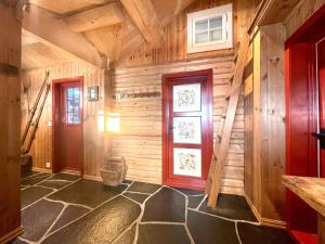 a hallway with wooden walls and a red door at Vasethytta - cabin with a lovely view in Brujordet