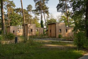 un grupo de edificios de madera en un bosque en Naturcamping Brettmühlenteich, 