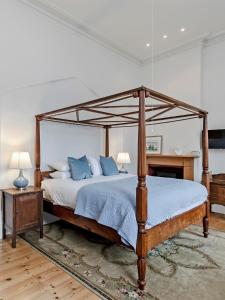 a bedroom with a canopy bed with blue pillows at Annesley House in Portland