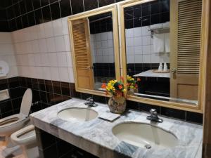 a bathroom with two sinks and a toilet at Holiday Plaza Hotel - Cebu in Cebu City