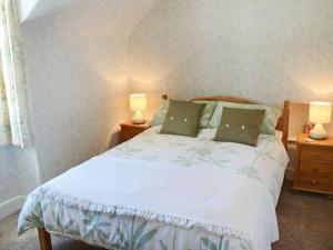 a bedroom with a large bed with two night stands at Old Midoxgate Farmhouse in Calrossie