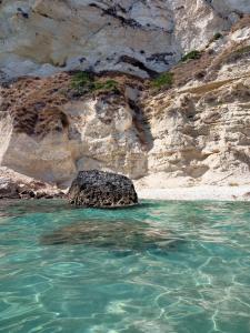 a rock in the water next to a beach at Nice in Elmas