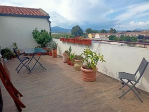 d'un balcon avec une table, des chaises et des plantes en pot. dans l'établissement Nice, à Elmas