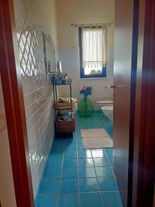 a bathroom with a blue tiled floor and a tub at Nice in Elmas