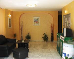 a living room with orange walls and a couch and chair at ORION Guest House in Sozopol